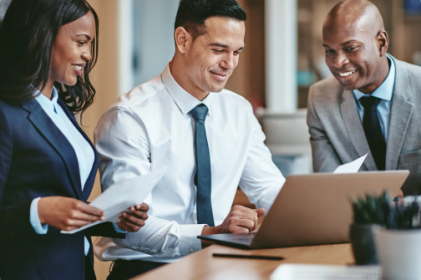 Employees sat round a laptop working